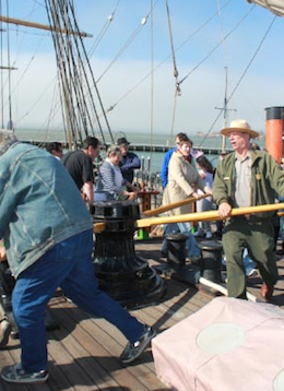 Ranger Peter Kasin (right) leads chantey workshoppers around the capstan of the Balclutha, to the tune of "Paddy Lay Back".   --- Photo by Jeff Kaliss