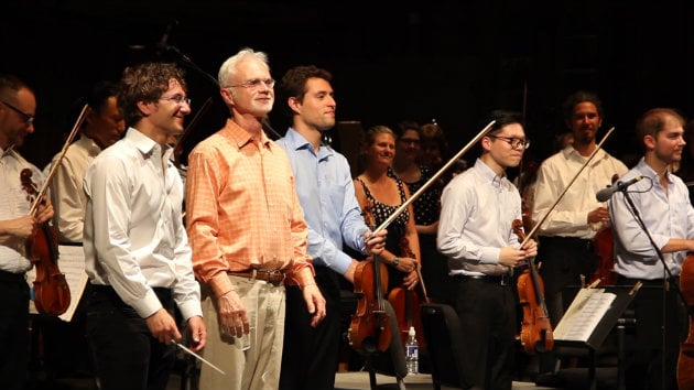 Teddy Abrams and John Adams taking a bow in front of the Dover String Quartet and the Britt Orchestra (Photo courtesy of musicmakesacity.com)