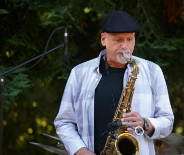 A portrait of Tod Dickow with his saxophone