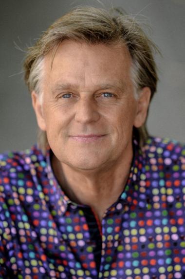 A portrait of pianist Stephen Prutsman, wearing a colorful polka dotted shirt