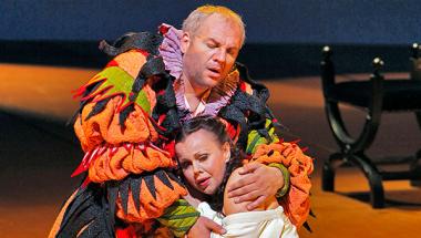 A photograph of Quinn Kelsey as Rigoletto and Nino Machaidze as Gilda in Verdi's "Rigoletto." The two kneel on stage, clinging together in a desperate embrace. Photo by Cory Weaver/San Francisco Opera