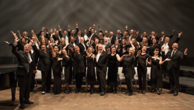 A photo of the San Francisco Opera Chorus dressed in all black attire.
