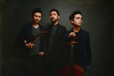 The Junction Trio stand up to pose for a studio photo while the violinist and cellist hold their instruments