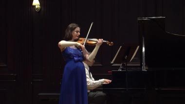 Musician Dorisiya Yosifova playing violin with a grand piano accompaniment
