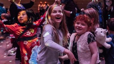Kids dancing and having fun under the disco ball at the Dance-Along Nutcracker