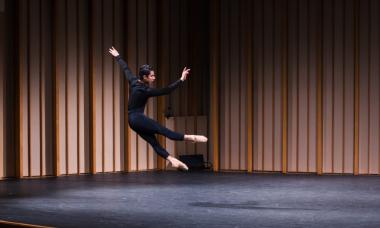 A dance student mid-air in a leap.