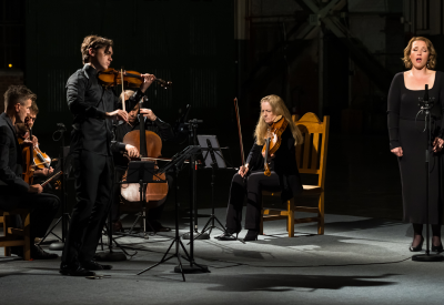 Image of violinist Benjamin Beilman, mezzo Sasha Cooke, and the St. Lawrence String Quartet in a performance dressed al in black
