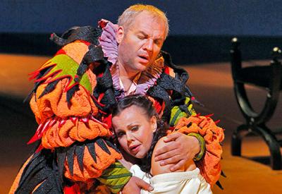 A photograph of Quinn Kelsey as Rigoletto and Nino Machaidze as Gilda in Verdi's "Rigoletto." The two kneel on stage, clinging together in a desperate embrace. Photo by Cory Weaver/San Francisco Opera