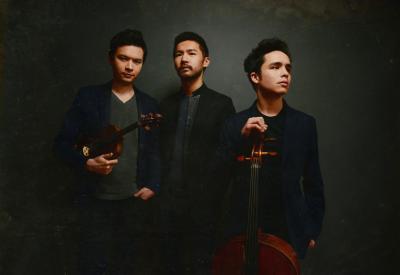 The Junction Trio stand up to pose for a studio photo while the violinist and cellist hold their instruments
