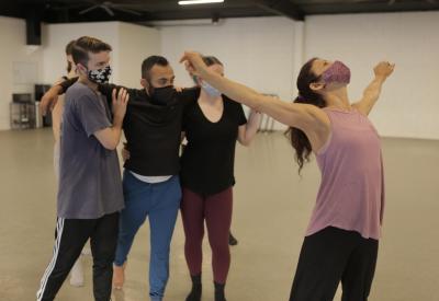 In-studio rehearsal photo of sjDANCEco Co-Artistic Director Maria Basile (in pink shirt) demonstrating movement from Yield to her dancers. Dancers (left to right) are: Ryan Tucker, Kevin Gaytan and Kyleigh Carlson.   Photo by Tom Hassing courtesy of sjDANCEco.