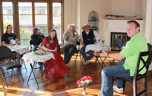 Sergei Chelakov (right) entertains his fellow musicians/contractors at the site of a new house concert series hosted by J.J. Hollingsworth (in red dress). Photo by Jeff Kaliss 