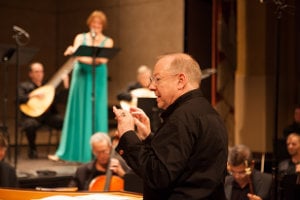 Nicholas McGegan conducting, with Diana Moore as Spring in the background (Photo courtesy of Philharmonia Baroque)